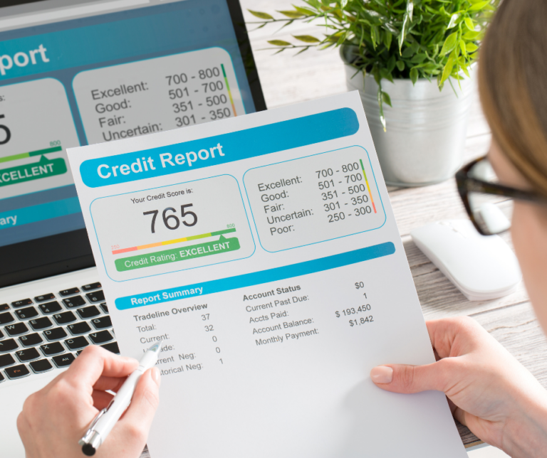 Person reviewing a credit report showing a 765 excellent credit score on a laptop during a spring credit checkup to monitor financial health