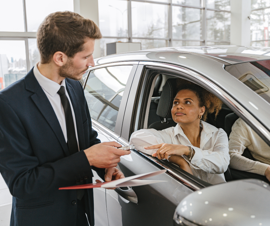 Car buyer discussing credit score and interest rates with a dealership salesperson
